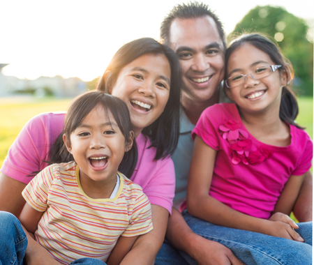 Two adults and two children sitting together and smiling